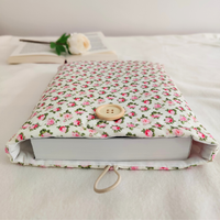 close view of the Pink Petals book sleeve with a book inserted, showcasing the secure button closure